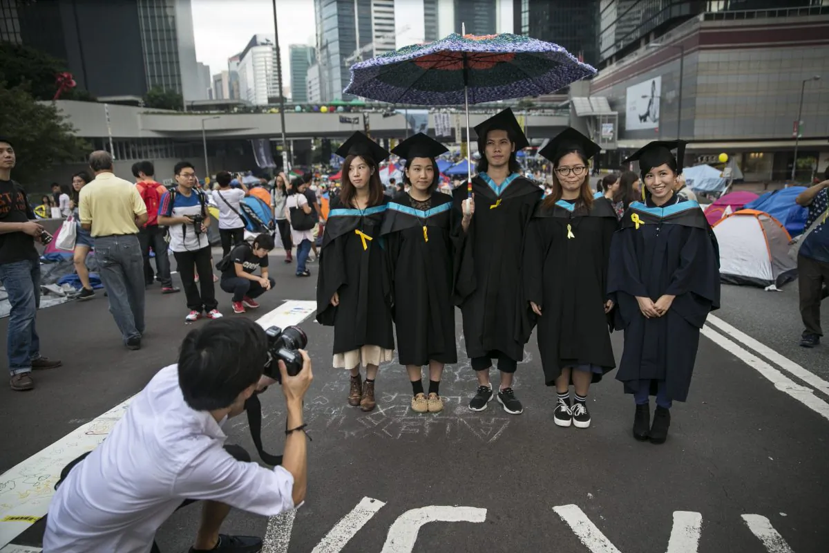 Graduates from the Hong Kong Polytechnic University pose for souvenir photos after their graduation ceremony at a main protest site of the Umbrella Movement on as a festival atmosphere prevails Oct. 26, 2014 in Hong Kong. In the aftermath of the pro-democracy protests, Hong Kong university students have shown a suspicion of communist influence on their campuses. (Paula Bronstein/Getty Images)