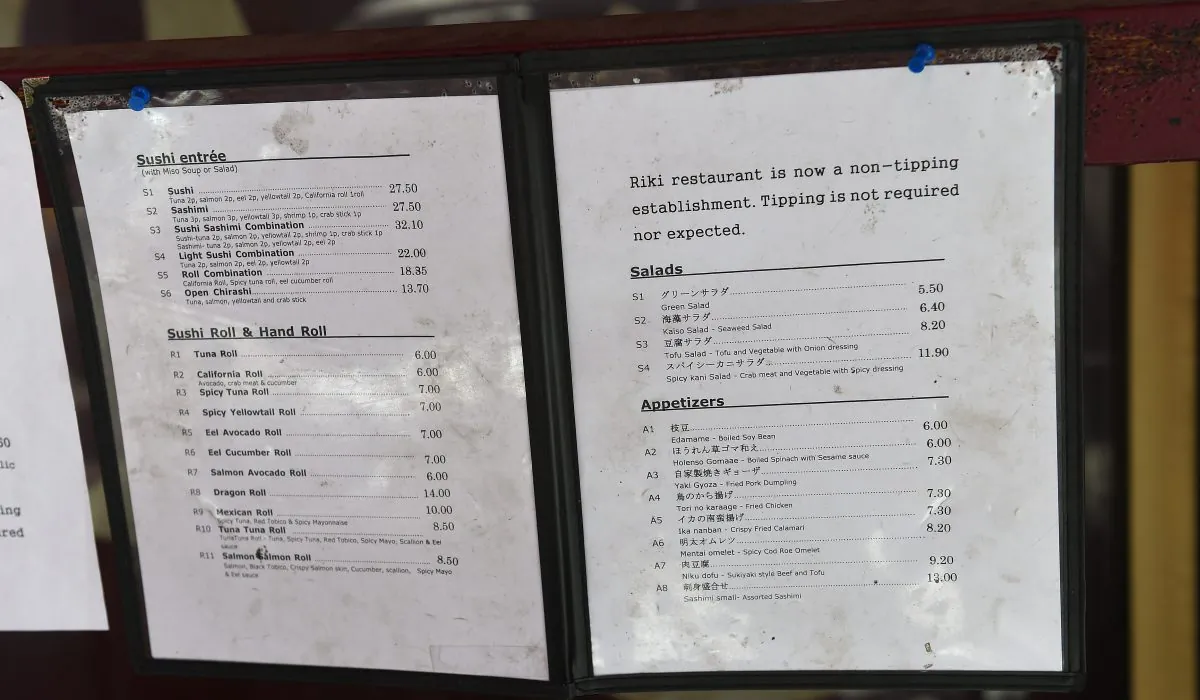 A menu displays a non-tipping policy in front of Japanese restaurant Riki in New York on May 1, 2014. A number of restaurants across the United States have decided to discourage patrons from tipping and to include the service charge in the bill. (Emmanual Dunand/AFP/Getty Images)