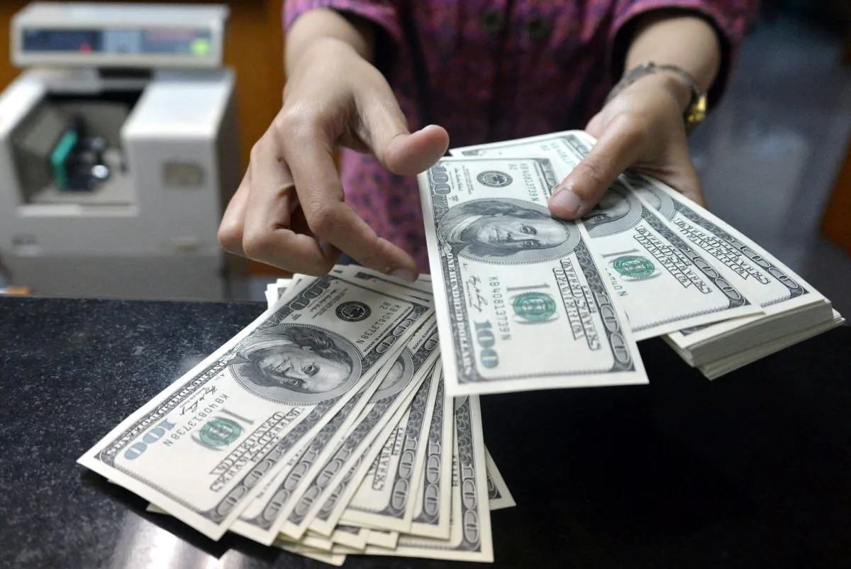 An employee counts U.S. notes at a money change outlet in Jakarta, Indonesia. (BAY ISMOYO/AFP/Getty Images)