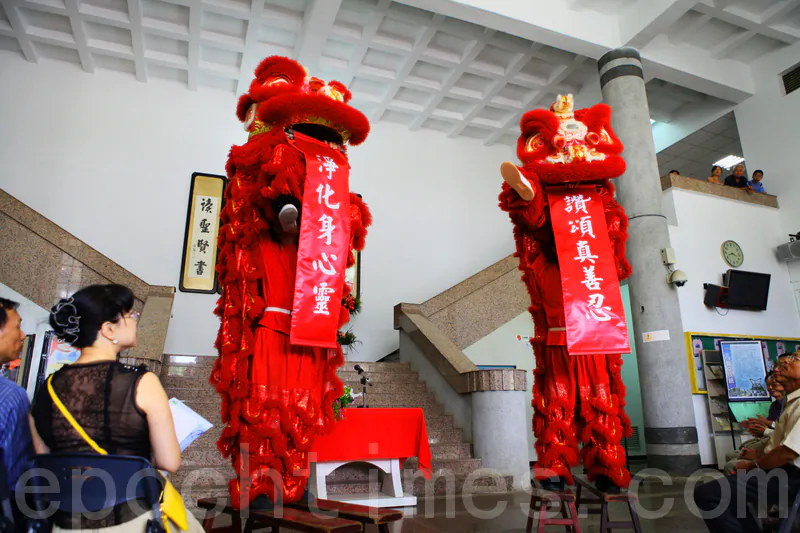 Energetic lion dancers present a modern couplet. The complementary pair translate as: Praise truthfulness, compassion, and tolerance; Purify body, mind, and spirit. (Lin Weiyu/Epoch Times)
