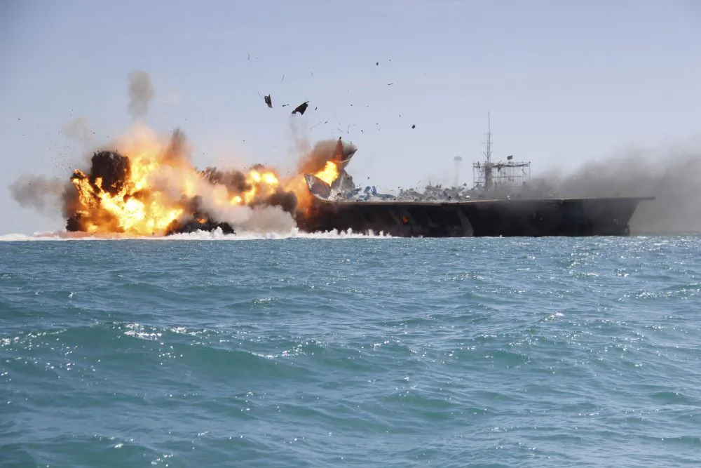 In this picture released by the Iranian Tasnim news agency on Wednesday, Feb. 25, 2015, a replica of a U.S. aircraft carrier is exploded by the Revolutionary Guard's speedboats during large-scale naval drills near the entrance of the Persian Gulf, Iran. The drill, named Great Prophet 9, was the first to involve a replica of a U.S. carrier. Cmdr. Kevin Stephens, the spokesman for the U.S. Navy's 5th Fleet in Bahrain, said they were monitoring the drills, but downplayed the simulated attack on the carrier, saying the U.S. military was "not concerned about this exercise."(AP Photo/Tasnim News)