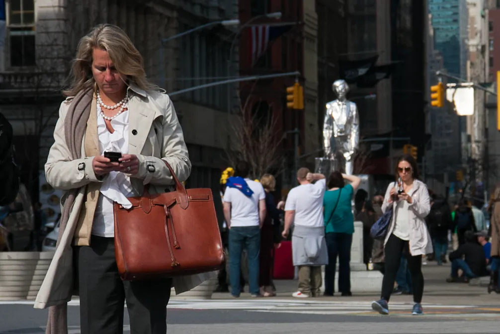 A woman uses her smartphone in Union Square on March 8, 2012. (Benjamin Chasteen/Epoch Times)