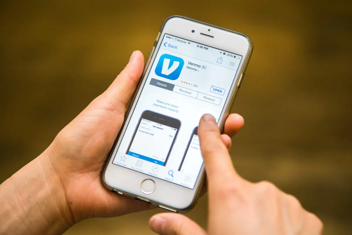 A person downloads the Venmo app on their iPhone in New York on March 1, 2015. (Benjamin Chasteen/Epoch Times)