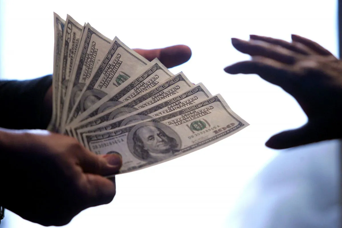 $100 dollar bills are exchanged at a local bank in Beijing on May 6, 2006. (STR/AFP/Getty Images)