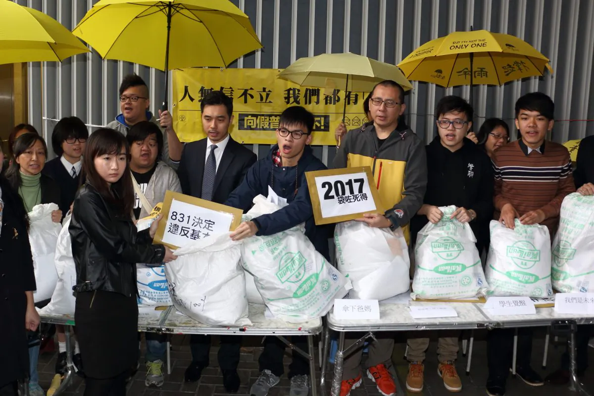 Scholarism spokesman Oscar Lai (C) and leaders of seven other pro-democracy groups present petition letters from residents to the Hong Kong government outside the Legislative Council in Hong Kong on Mar. 4, 2015. (Kiri Choi/Epoch TImes)