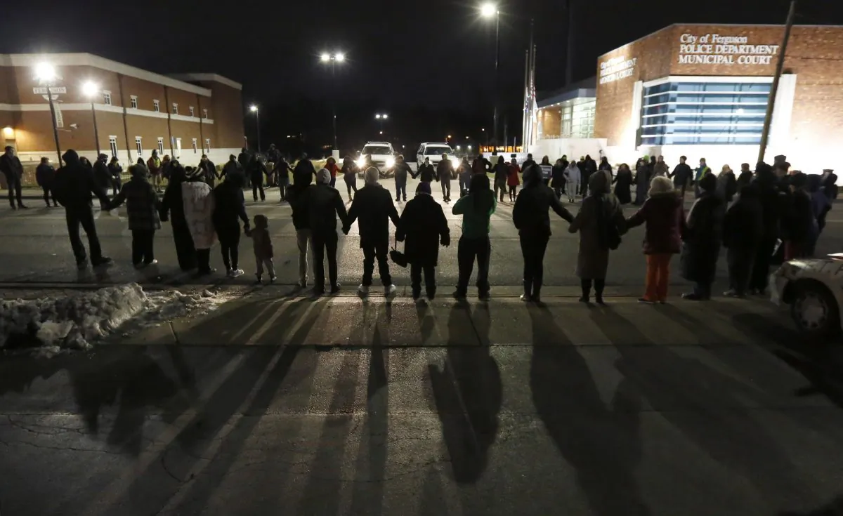 Protestors block traffic outside the Ferguson Police Department, Wednesday, March 4, 2015, in Ferguson, Mo., after the Department of Justice released a report documenting abuses within the police department. (AP Photo/Charles Rex Arbogast)