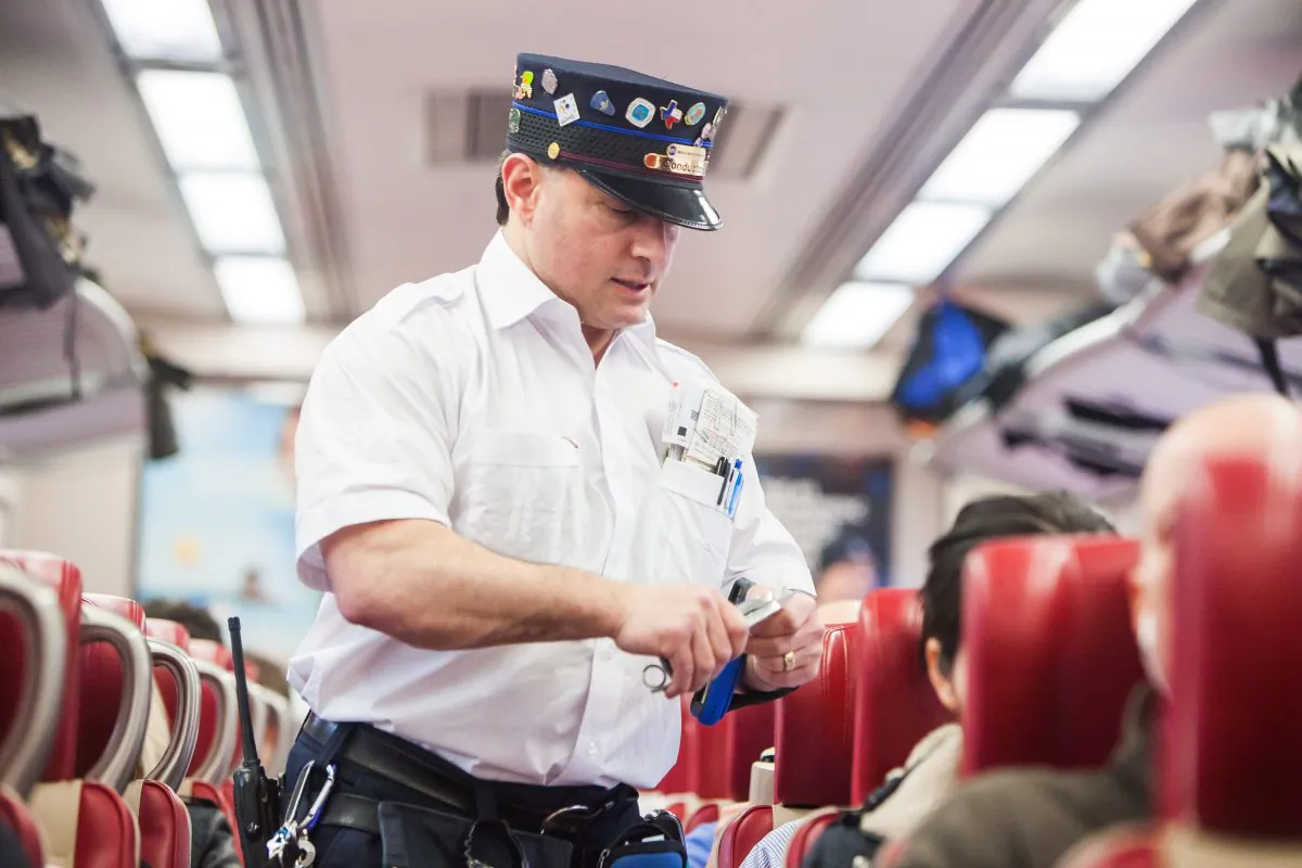 Metro North train conductor Steve Macchio, inspects tickets on the 4 p.m. train from Grand Central Terminal in New York City to New Haven on March 27, 2015. (Petr Svab/Epoch Times)