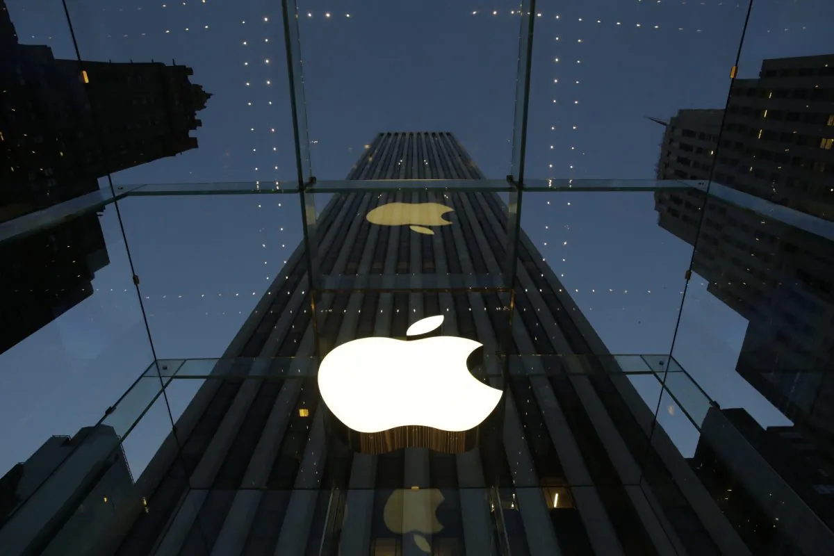 In this Wednesday, Nov. 20, 2013, file photo, the Apple logo is illuminated in the entrance to the Fifth Avenue Apple store, in New York. (AP Photo/Mark Lennihan)