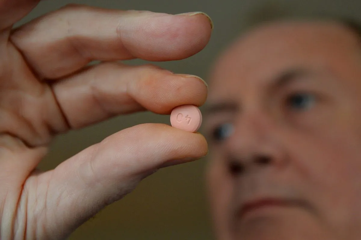 Alwyn Daniel with a tablet of the anti-cholesterol drug statins in London on March 21, 2014. (Ben Stansall/AFP/Getty Images)