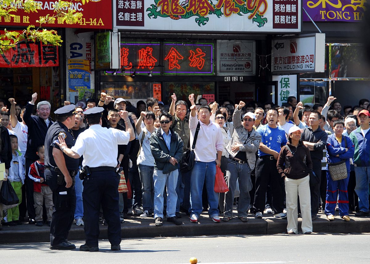 Police monitor pro CCP members yell threats and insults at Falun Gong practitioners who are across the street in Flushing, New York, in June 2008. (Epoch Times)
