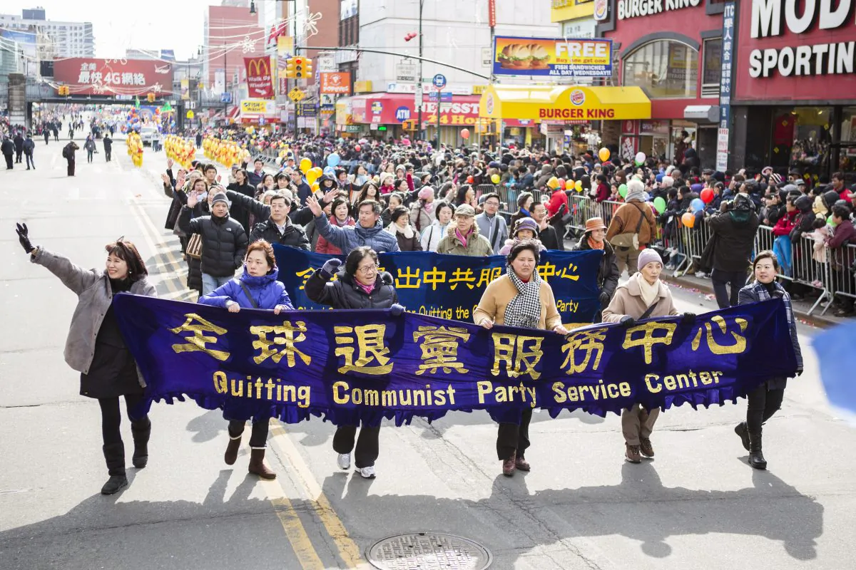 Falun Gong practitioners carry a banner asking people to quite the Chinese Communist Party during a parade in Flushing in 2014. (Dai Bing/Epoch Times)