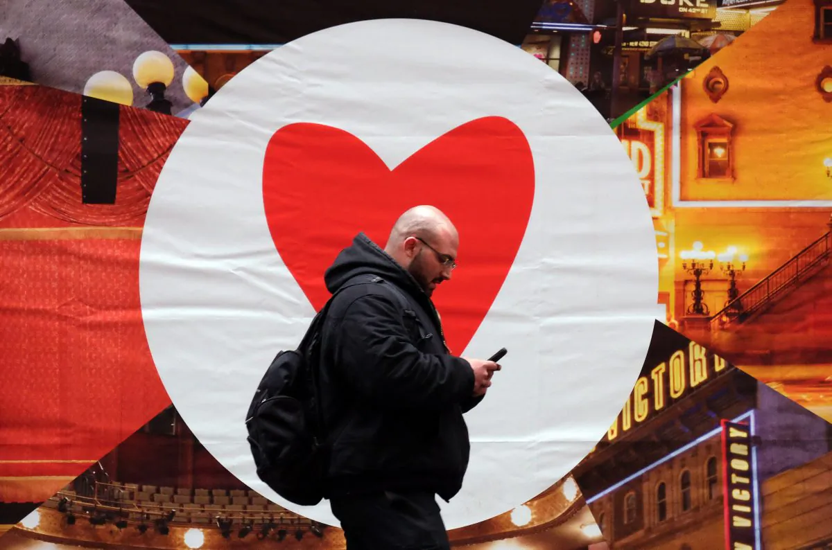 A man texts on his smartphone as he walks along a street in New York on March 4, 2015. Social dating app Tinder announced it will limit right swipes, in effort to emulate real life relationships. (Jewel  Samad/AFP/Getty Images)