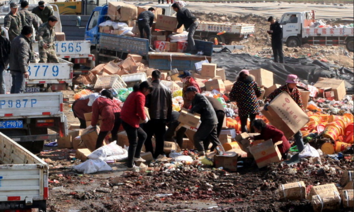 A photograph on Sina News, a Chinese website, shows people in the city of Xuzhou, Jiangsu Province, scrambling to salvage the boxes of substandard and counterfeit foodstuffs being destroyed and discarded by local authorities on March 11. Some came back for several helpings. (Screenshot/Epoch Times)