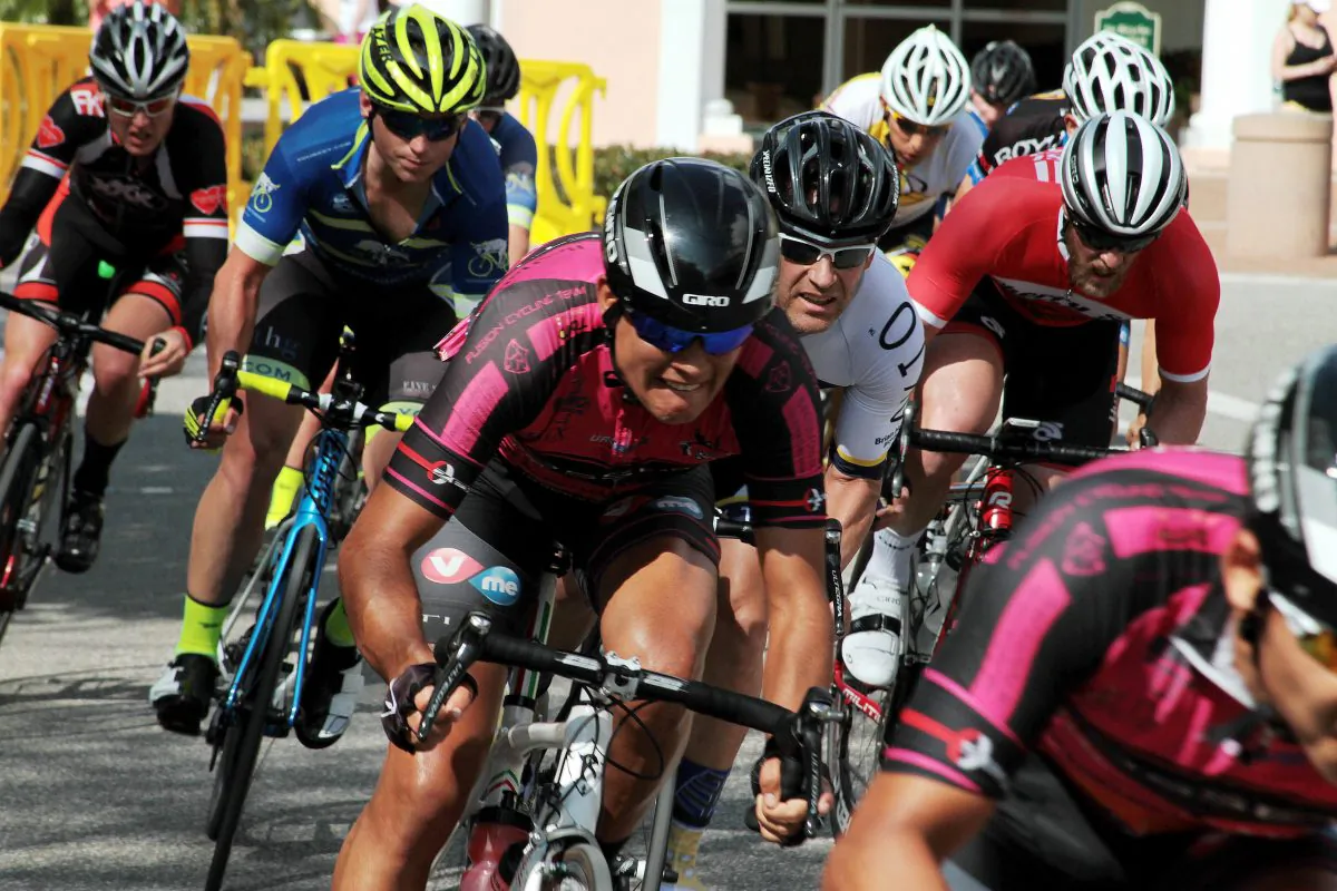 A pack of cyclists races shoulder-to-shoulder around a tight corner at 30 mph during the Chain of Lakes Cycling Classics Criterium in downtown Winter Haven, Fla March 1, 2015 (Chris Jasurek/Epoch Times)