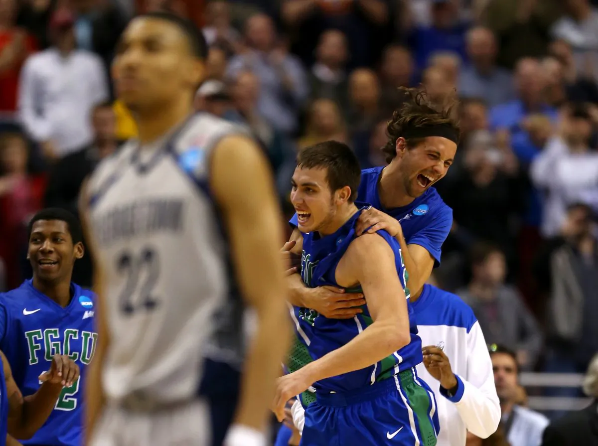 Christophe Varidel (center-top) and Chase Fieler (center-bottom) of the Florida Gulf Coast Eagles celebrate their 78-68 win as Otto Porter Jr. of the Georgetown Hoyas walks off of the court dejected during the second round of the 2013 NCAA Men's Basketball Tournament at Wells Fargo Center on March 22, 2013 in Philadelphia, Pennsylvania. (Elsa/Getty Images) 
