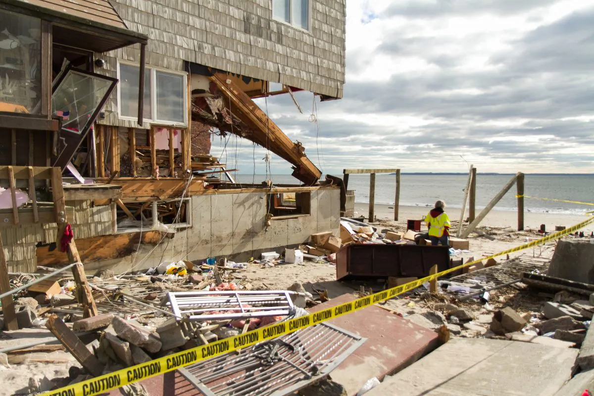 A women who works for a gas company, surveys the area of a house that was destroyed by Hurricane Sandy at Sea Gate Beach in Brooklyn on Jan. 8, 2013. (Kristen Meiwether/Epoch Times)