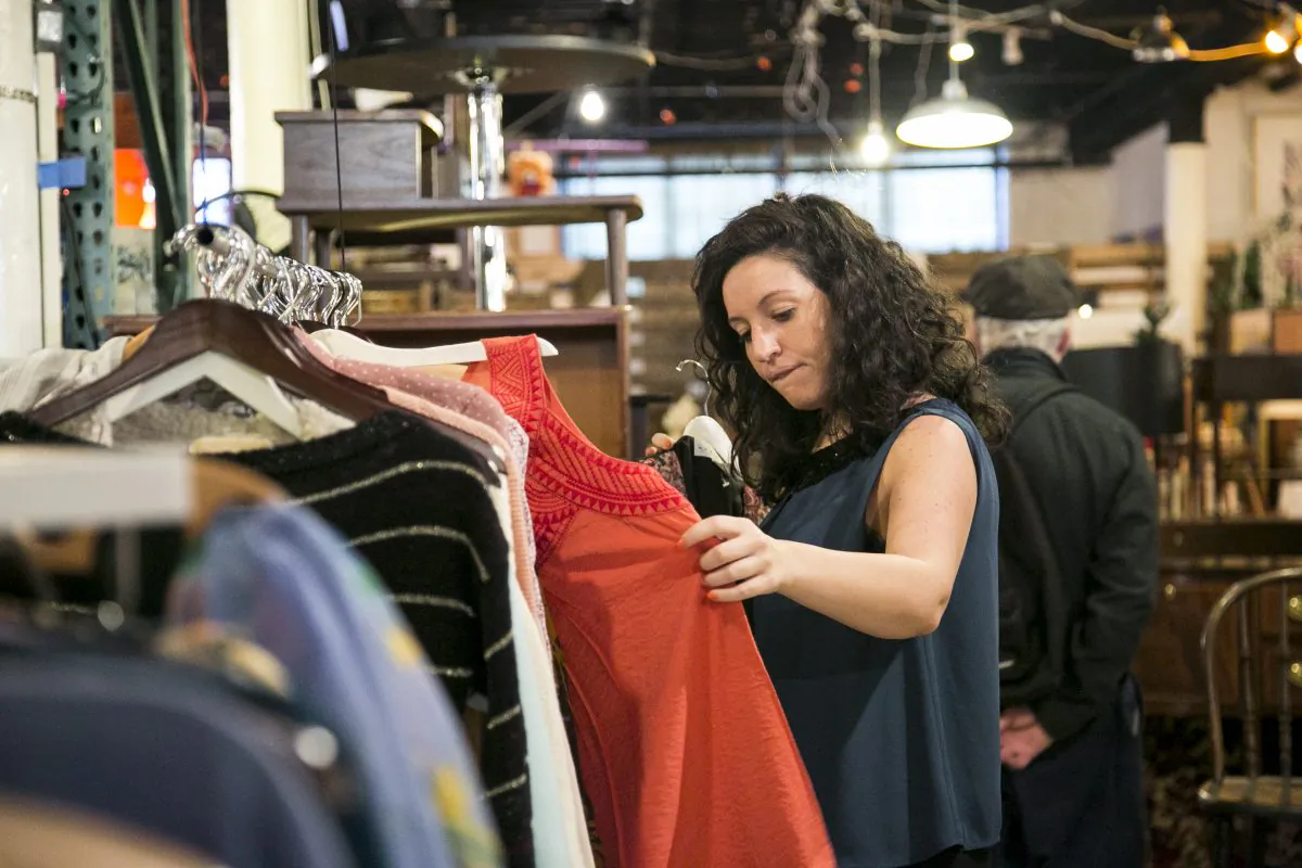A woman looks through vintage clothes at Film Biz Recycling, a shop that sells donated items from movie and theater sets, in the Gowanus area of Brooklyn, New York, on Oct. 30, 2014. (Samira Bouaou/Epoch Times)