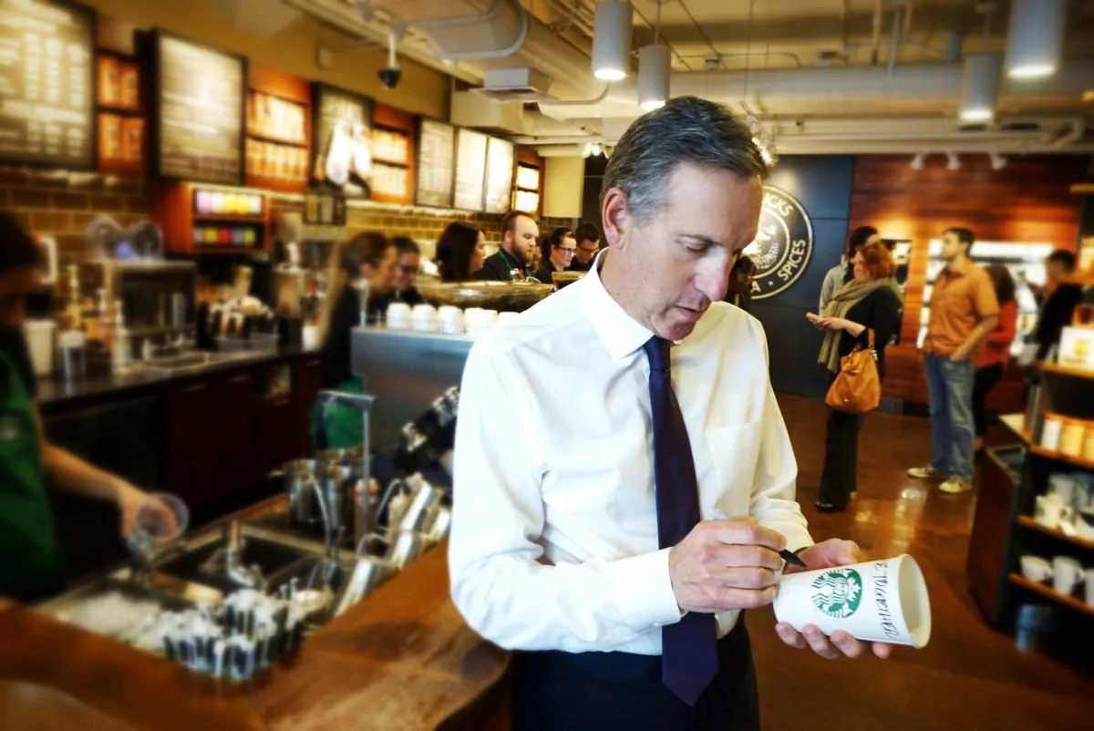 Starbucks CEO Howard Schultz, writes RaceTogether on a cup in a store in Seattle. (Starbucks Corporation)