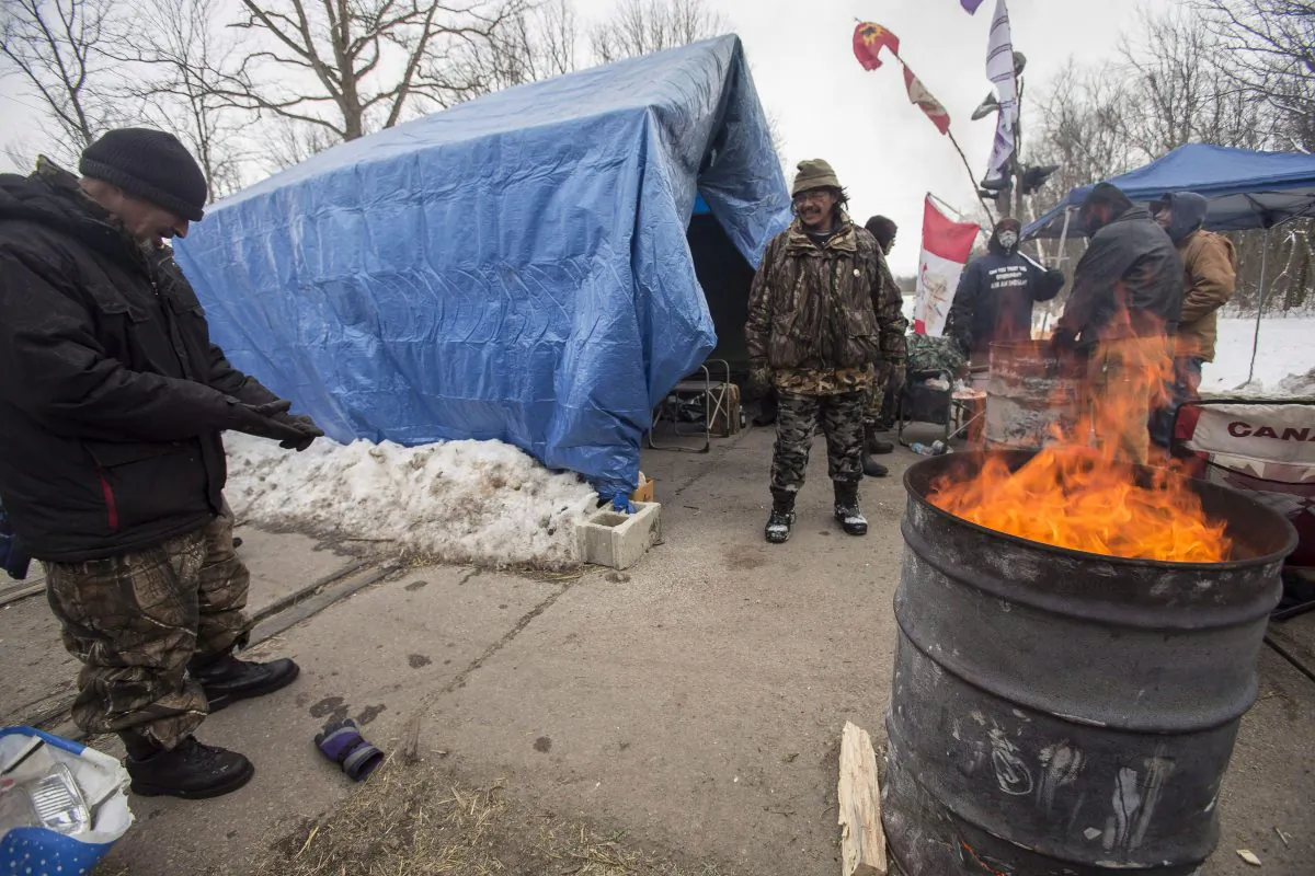 First Nations protesters continue their blockade of the CN tracks in Sarnia, Ont., on Jan. 2, 2013, after a court injunction to have them move was issued over the holidays. The protest, which blocked the tracks for 13 days, was mentioned as a concern in a federal analysis of protests in Canada. (The Canadian Press/ Geoff Robin)