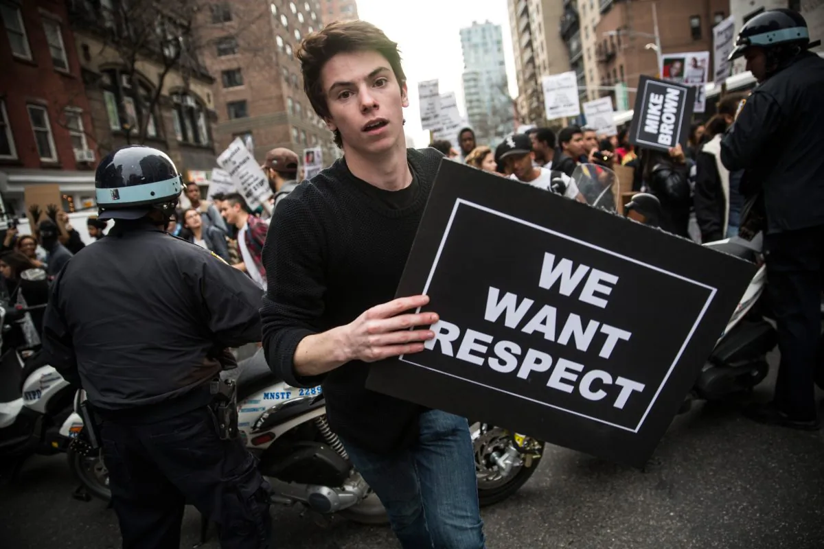 A man protesting the Ferguson grand jury decision to not indict officer Darren Wilson in the Michael Brown case breaks through police lines attempting to get protesters on the sidewalk while marching through the streets on December 1, 2014 in New York City. (Andrew Burton/Getty Images)