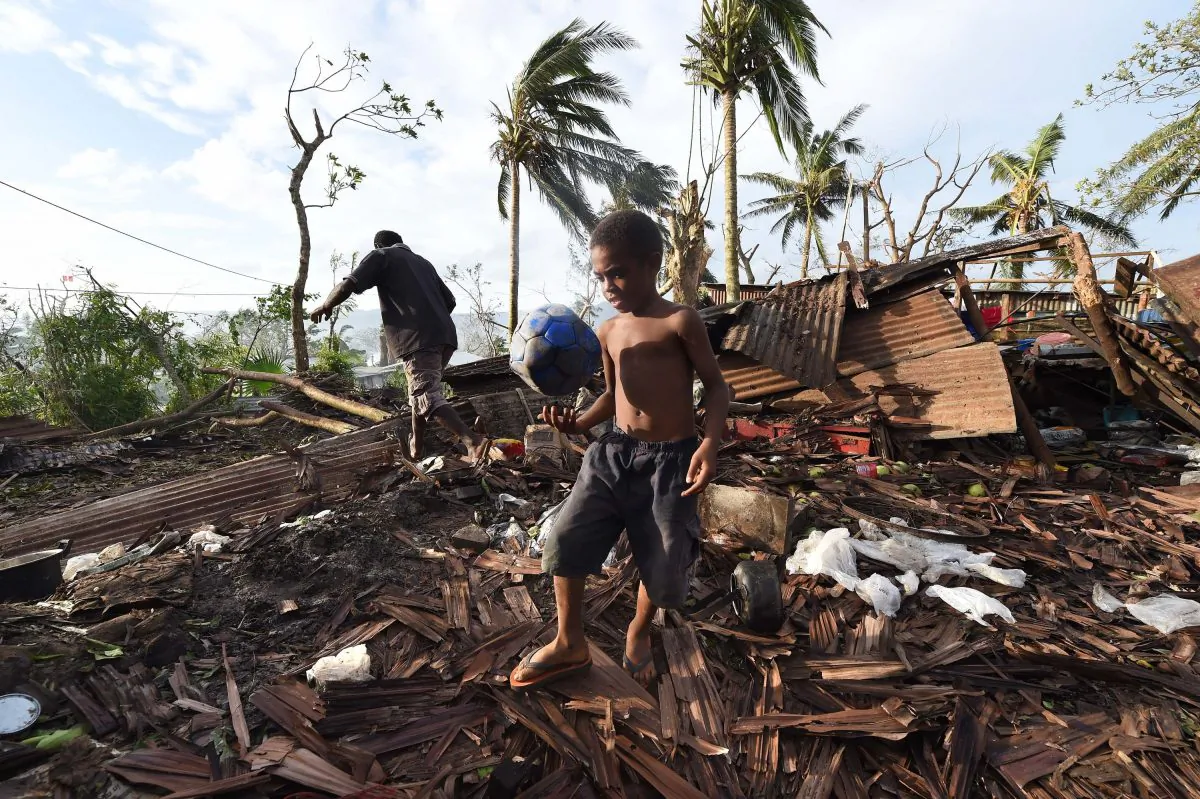 A local Vanuatu boy named Samuel walks through through the ruins of his family home with his father Phillip, in Port Vila on March 16, 2015.  (Dave Hunt-Pool/Getty Images)