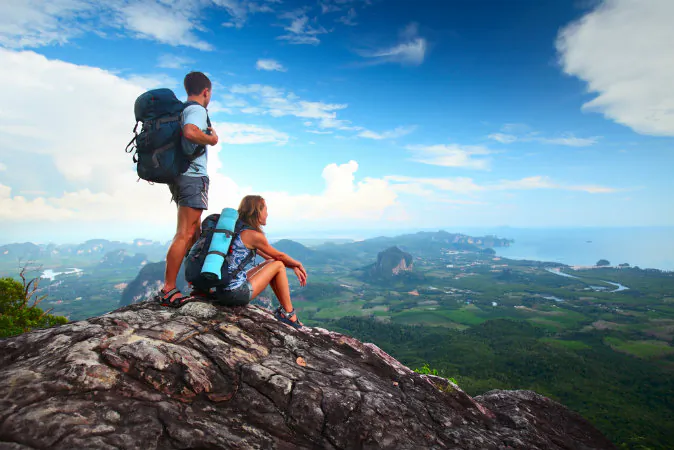 Young tourists with backpacks enjoying valley view via Shutterstock*