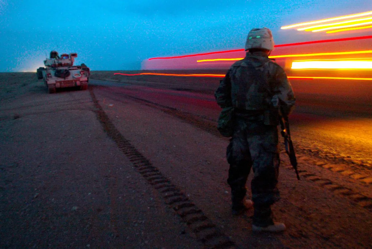 A soldier from the U.S. Army A Company 3rd Battalion 7th Infantry Regiment watches the blur of a convoy of 3rd Infantry Division forces as it passes by, pushing deeper into Iraq from the south Saturday, March 22, 2003. (AP Photo/John Moore)