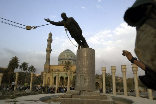 A U.S. marine watches a statue of Saddam Hussein being toppled in downtown Bagdhad Wednesday April 9, 2003. (AP Photo/Jerome Delay)