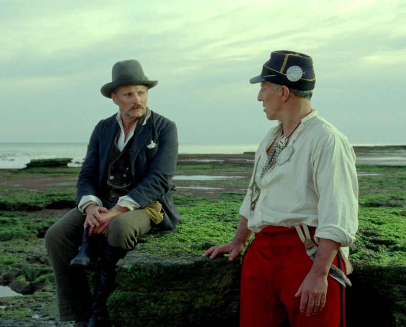two men talking on a grassy rock in "Jauja"