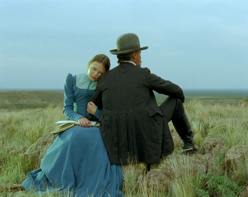 girl and man sit and look at grass in "Jauja"