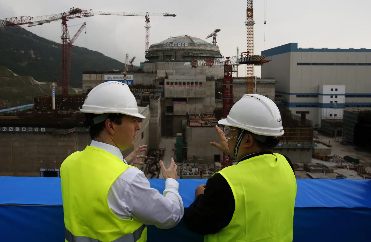 British Chancellor of the Exchequer George Osborne (L) speaks with Taishan Nuclear Power Joint Venture general manager Guo Liming in front of a nuclear reactor under construction at a nuclear power plant in Taishan, Guangdong province, on October 17, 2013. The Chinese regime is trying to win several contracts to build nuclear power facilities in other countries. (BOBBY YIP/AFP/Getty Images)