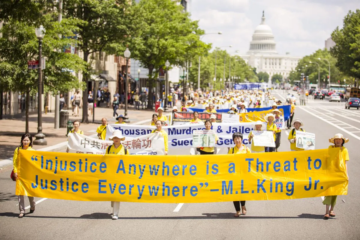 Falun Gong practitioners march in a parade calling for an end to the persecution in China, as the U.S. Capitol building is in the background, in Washington, D.C., on July 17, 2014. (Edward Dai/Epoch Times)