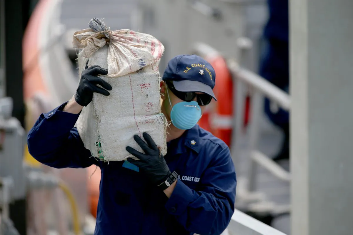 A U.S. Coast Guard member helps offload bags of seized cocaine worth an estimated WHOLESALE value of more than $23 million in Miami Beach, Fla., on Sept. 18, 2014. (Joe Raedle/Getty Images)