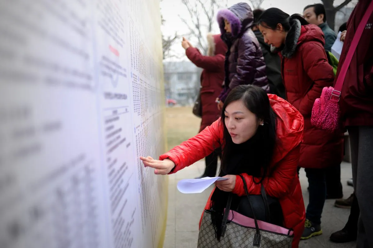 Students check room numbers for the National Entrance Examination for Postgraduate at a university in Beijing on January 4, 2014. Chinese college students cheating by hiring writers to write papers for them is reportedly rampant both in mainland China and overseas. (Wang Zhao/AFP/Getty Images)