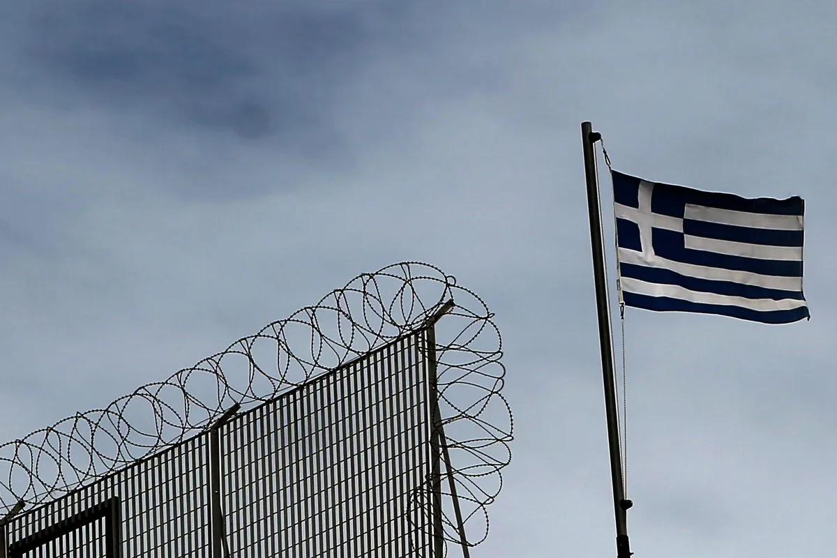 The Greek flag flutters atop a building in Athens on March 1, 2015. (Angelos Tzortzinis/AFP/Getty Images)