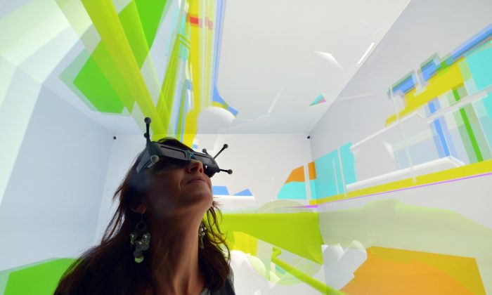 A woman wearing 3D glasses tests a Cave Automatic Virtual Environment (CAVE) virtual reality theatre during its presentation at the Industrial Centre for Virtual Reality in Saint-Nazaire on December 1, 2014. (Georges Gobet/AFP/Getty Images)