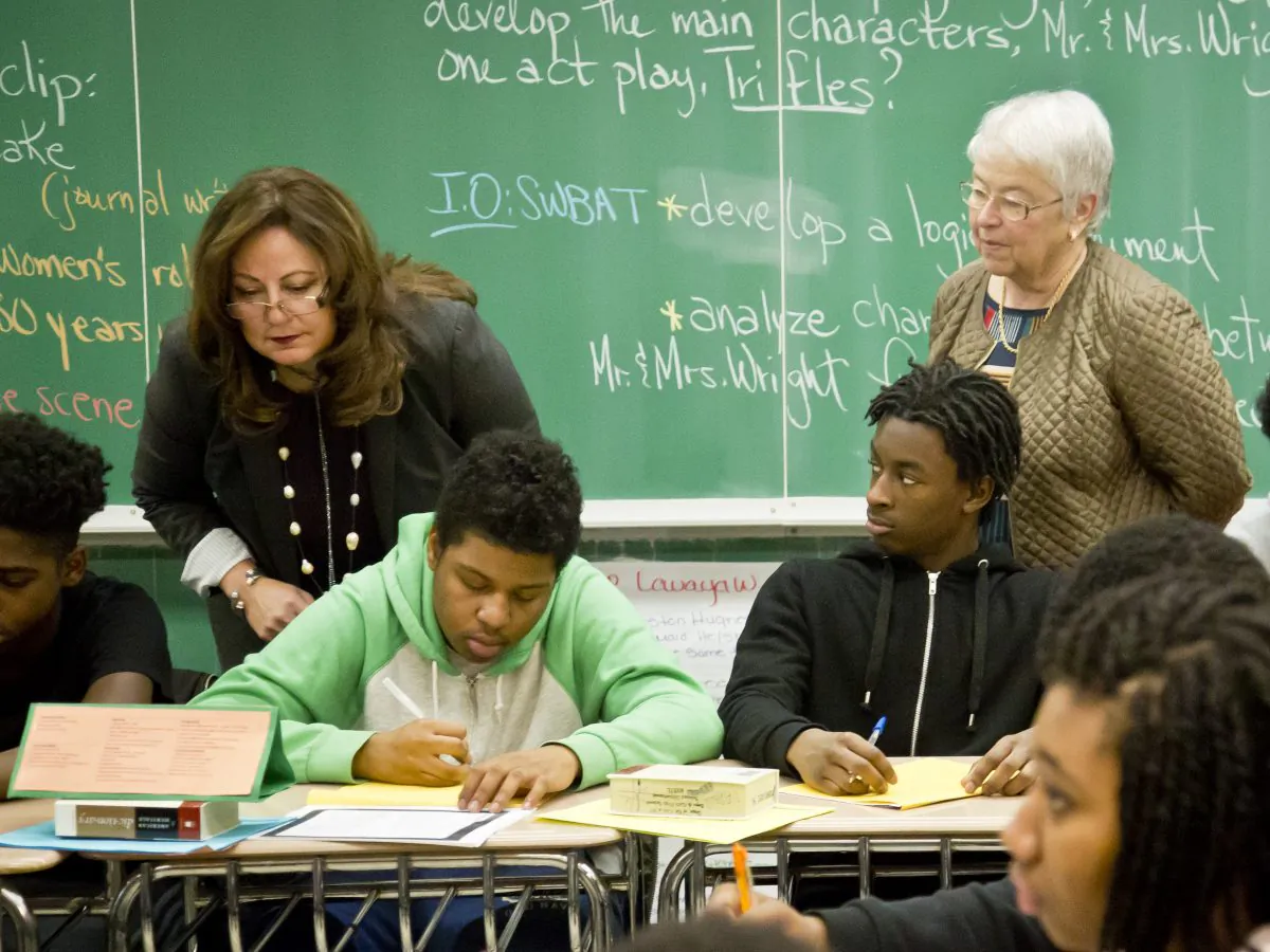 Aimee Horowitz, second from left, and and Schools Chancellor Carmen Fariña, far right, visit a 12th grade English class at Boys and Girls High School, Tuesday, March 10, 2015, in the Brooklyn borough of New York.  (AP Photo/Bebeto Matthews)