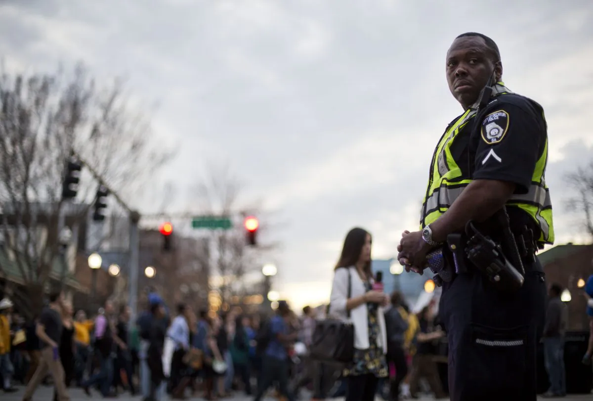 A police officer stands guard during a protest against the shooting death of Anthony Hill by police, Wednesday, March 11, 2015, in Decatur, Ga. (AP Photo/David Goldman)