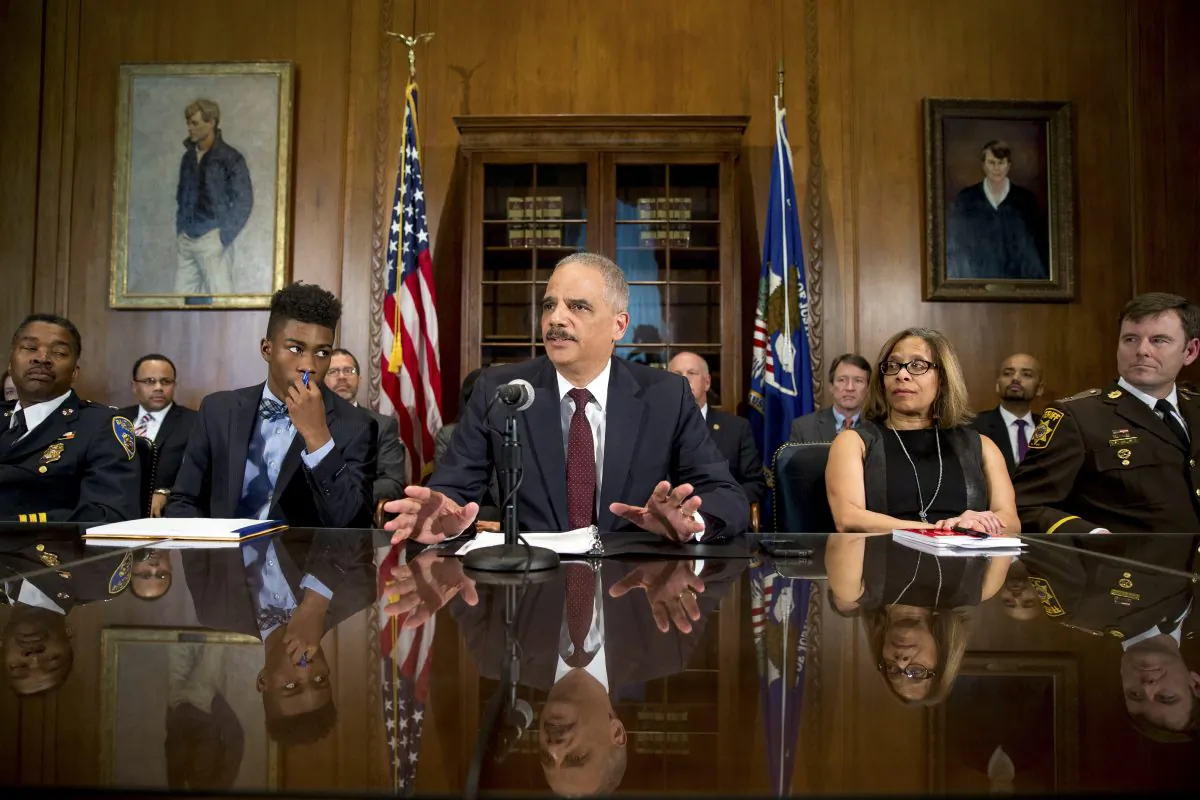 Attorney General Eric Holder, center, at a press conference held at the Department of Justice on Thursday, March 12, 2015, in Washington, D.C. (AP Photo/Andrew Harnik)