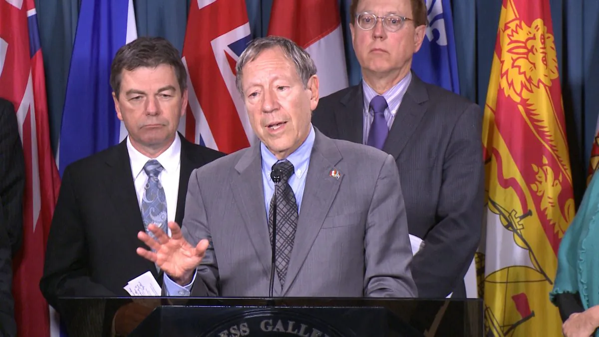 Liberal MP Irwin Cotler (C), flanked by Conservative MP David Anderson (L) and NDP MP Murray Rankin speaks during a press conference on Parliament Hill March 25, 2015. A motion by Cotler that would allow sanctions against those responsible for the detention, torture, and death in prison of Russian lawyer Sergei Magnitsky, as well as against foreign nationals responsible for human rights violations, has been unanimously adopted by the House of Commons. (NTD Television)