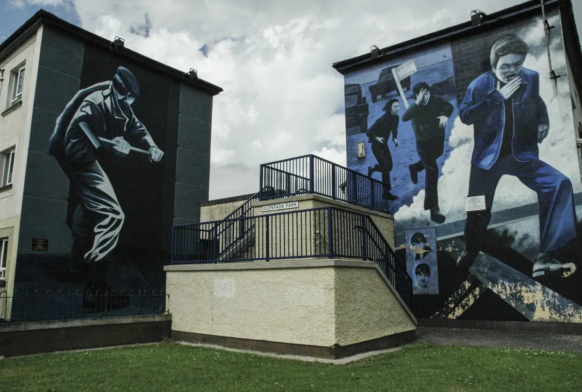 Undated image of murals showing a soldier smashing a barricaded door with a sledgehammer and Bogside residents fleeing from a teargas attack, in Londonderry, Northern Ireland. (Carole Jobin)