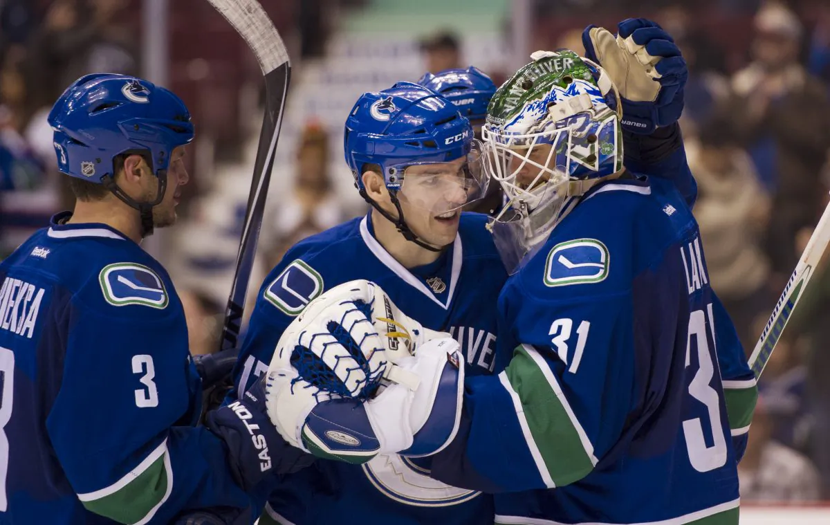 Goalie Eddie Lack is congratulated by teammates Radim Vrbata and Kevin Bieksa after the Vancouver Canucks defeated the Winnipeg Jets on March 24, 2015 at Rogers Arena in Vancouver. (Rich Lam/Getty Images)