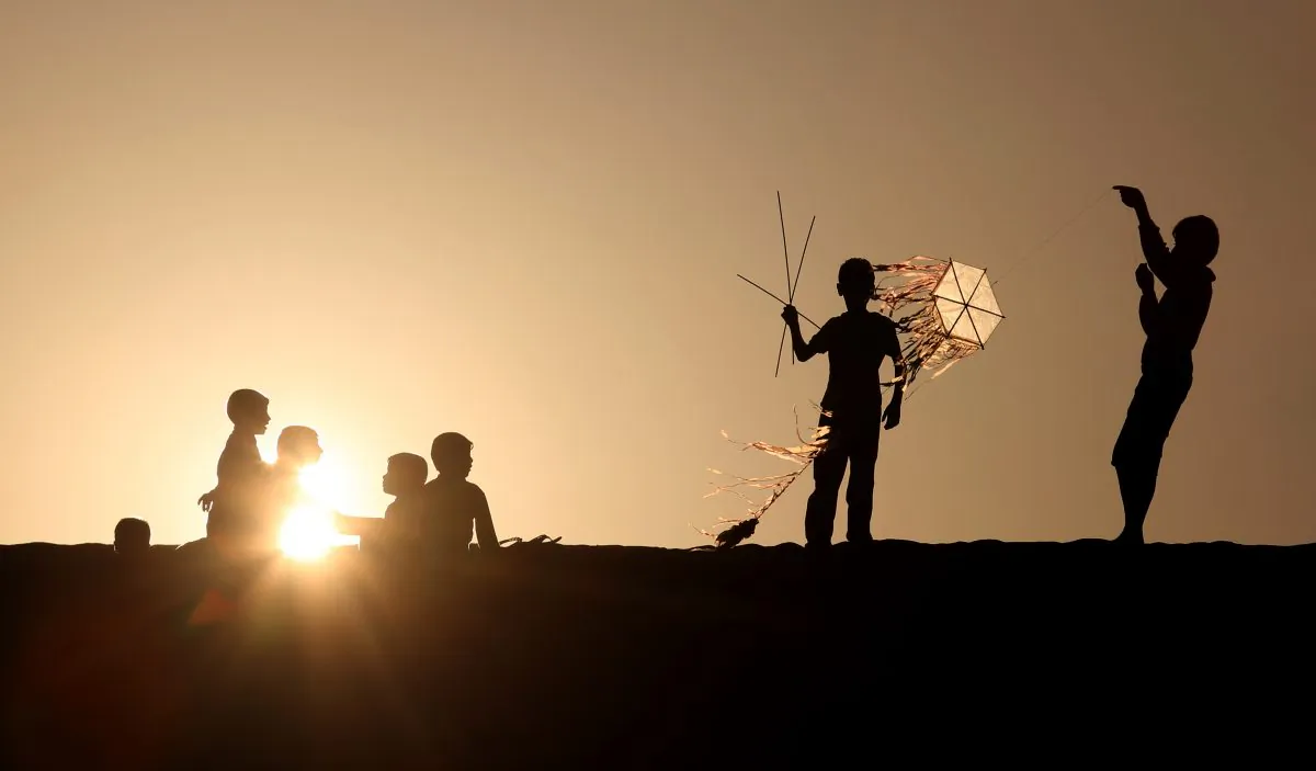 Palestinian children fly kites and sit watching the sunset n Khan Younis, a town and refugee camp in the southern Gaza Strip, Friday, Feb. 28, 2014. (AP Photo/Hatem Moussa)