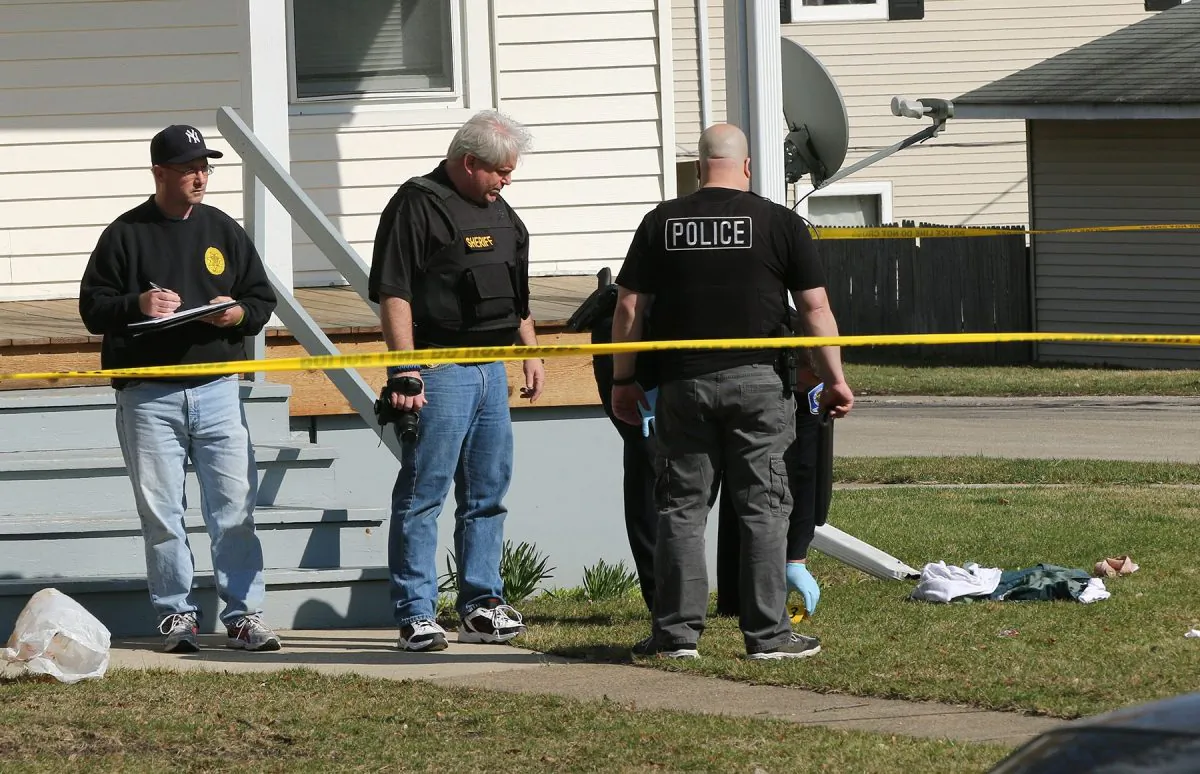 Investigators look over the scene following a police involved shooting in Zion, Ill. on Saturday, April 2, 2015, after a Zion Police officer was involved in a fatal shooting. (AP Photo/The Chicago Tribune, Joe Shuman)