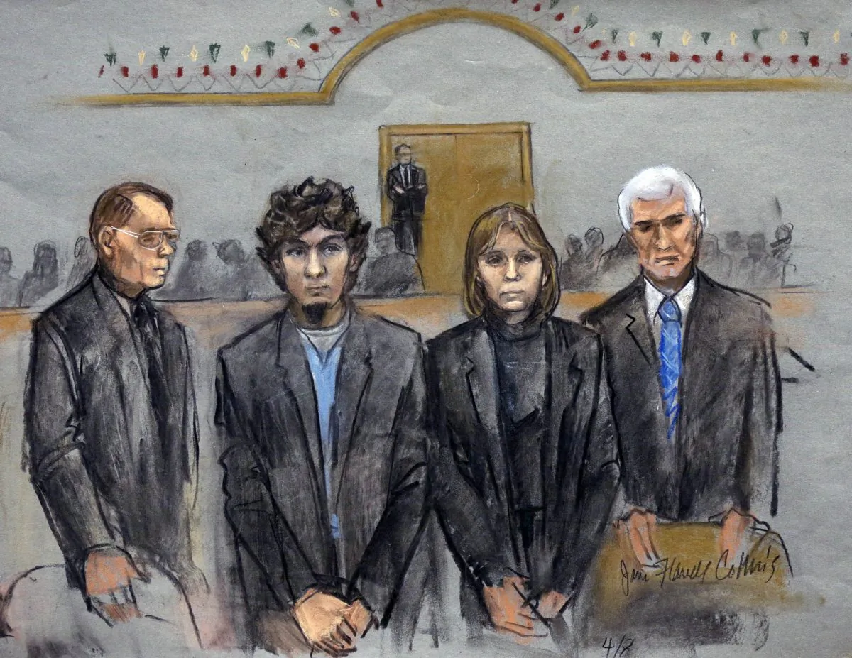 In this courtroom sketch, Dzhokhar Tsarnaev, second from left, is depicted standing with his defense attorneys as the jury presents its verdict in his federal death penalty trial Wednesday, April 8, 2015, in Boston. (AP Photo/Jane Flavell Collins)