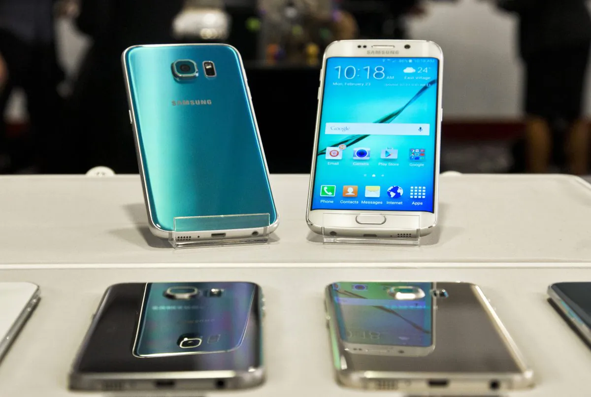 Two new Samsung phones, the Galaxy S6, top left, and Galaxy S6 Edge, top right, are on display at a special press preview in New York. (AP Photo/Bebeto Matthews)