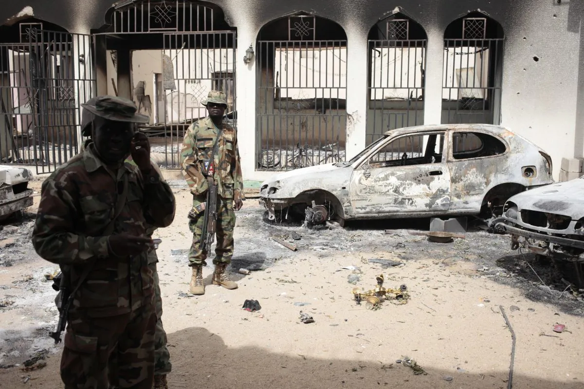 Nigerian soldiers stand guard in front of the burned out palace of the Emir of Gwoza, in Gwoza, Nigeria (AP/Lekan Oyekanmi)