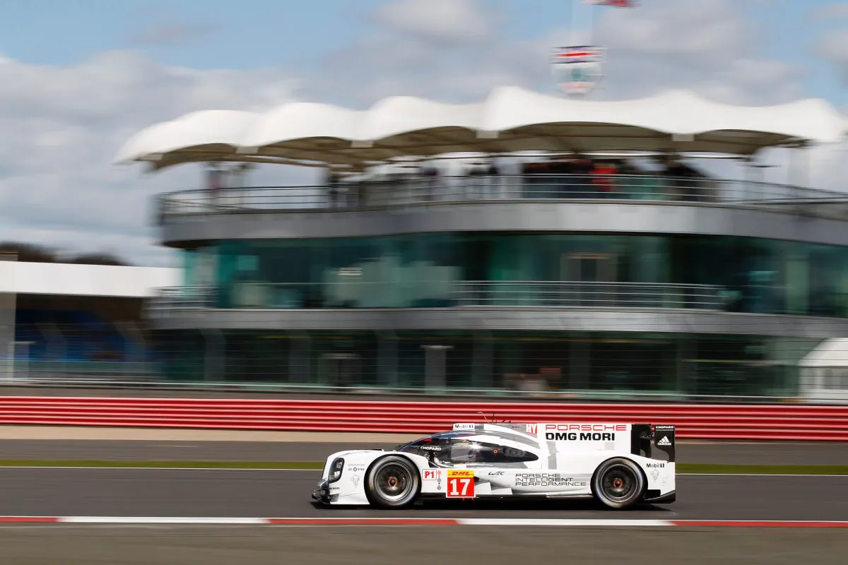 The #17 Porsche 919 Hybrid of Timo Bernhard, Brendon Hartley, and Mark Webber streaks past the buildings at Silverstone on its way to qualifying for the pole at the WEC Six Hours of Silverstone, April 11, 2015. (presse.porsche.de/)