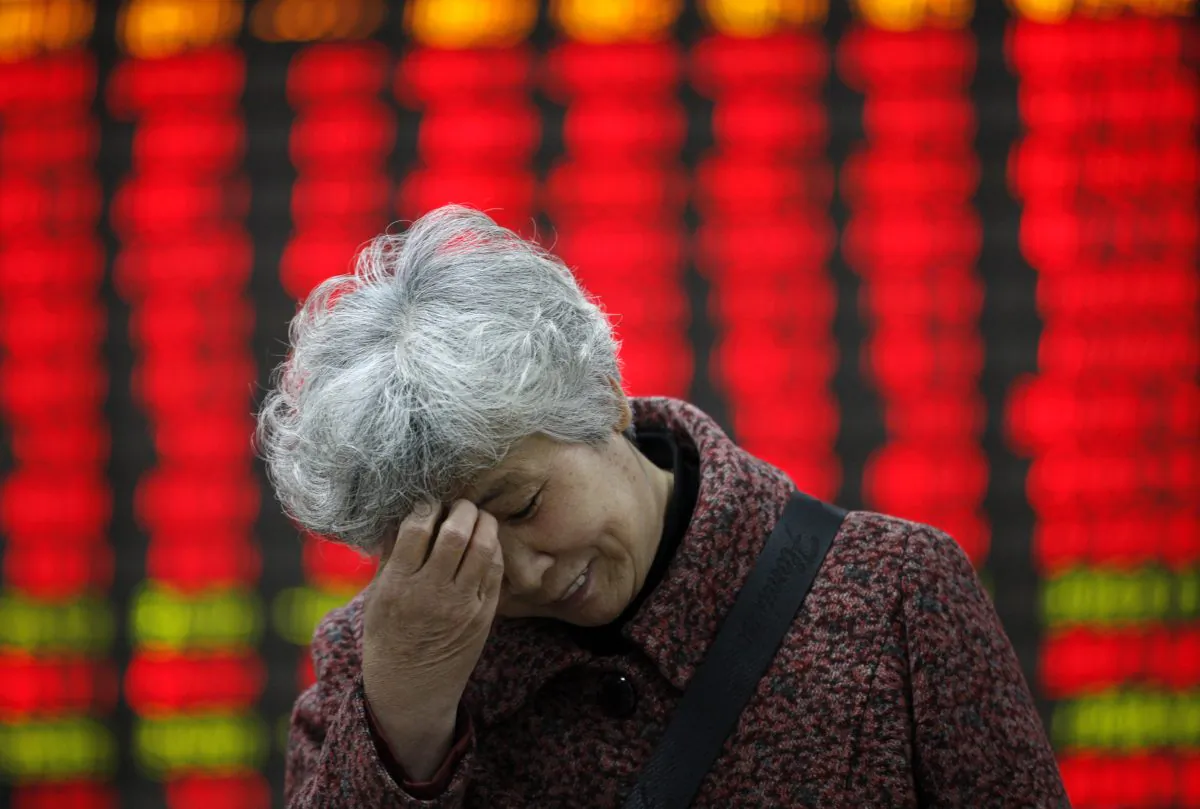 An investors stands in front of a stock ticker board on April 7 in Huaibei, Anhui Province, China.(ChinaFotoPress / Stringer)