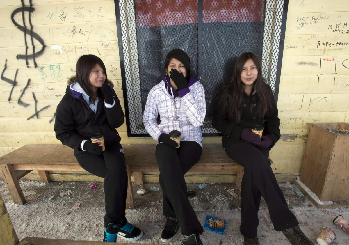 Teenage girls enjoy a coffee outside the local store on the Fort Hope First Nation in Ontario. Many of Canada’s First Nations communities have long grappled with poverty. The Live Below the Line challenge raises money for organizations that deliver programs focused on nutrition, water, health and sanitation, and education. (The Canadian Press/Ryan Remiorz)